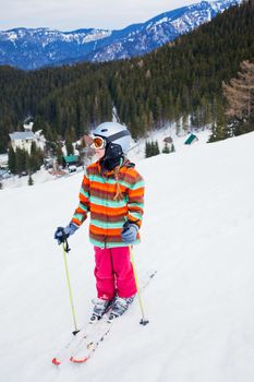 Girl on skis in soft snow on a sunny day in the mountains