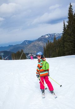 Girl on skis in soft snow on a sunny day in the mountains