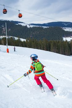Girl on skis in soft snow on a sunny day in the mountains