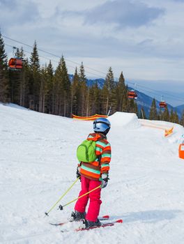 Girl on skis in soft snow on a sunny day in the mountains