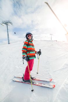 Girl on skis in soft snow on a sunny day in the mountains
