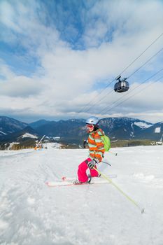 Girl on skis in soft snow on a sunny day in the mountains