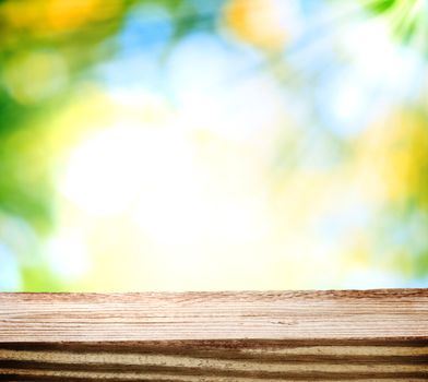 Wooden table over green and yellow shiny light background