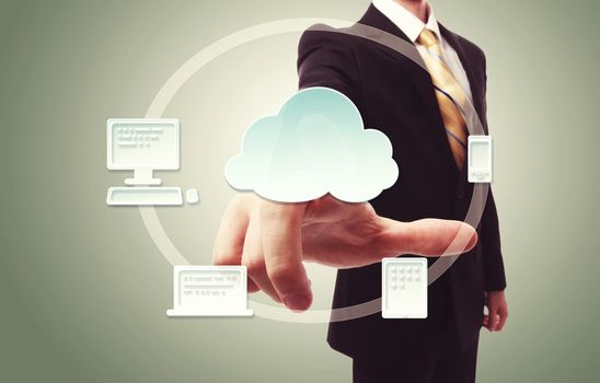 Businessman pressing cloud icon with devices over vintage green background