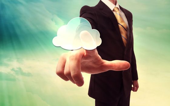 Businessman pressing a cloud computing icon on blue and yellow sky background