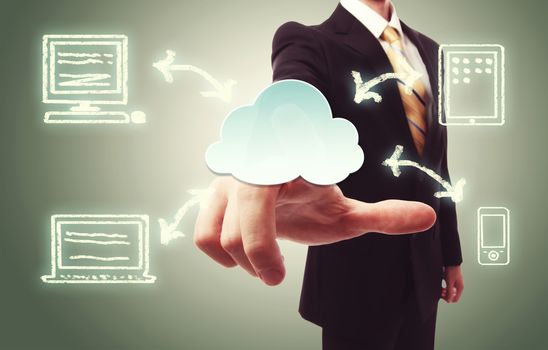 Businessman pressing a cloud icon with devices over vintage green background