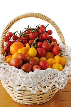 Different varieties of tomatoes in a basket on a wooden table