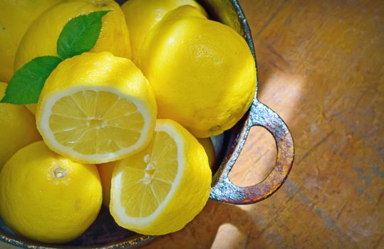 fresh lemons  in a old pan on a wood table
