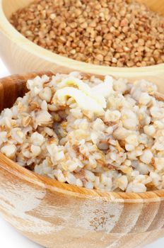 Two Wooden Bowls with Traditional Russian Buckwheat and Raw Buckwheat closeup