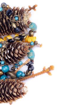 Frame of Fir Cones, Spruce Stems, Blue and Bronze Jewelry Beads isolated on white background