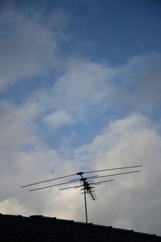 A TV antenna on a tiled roof