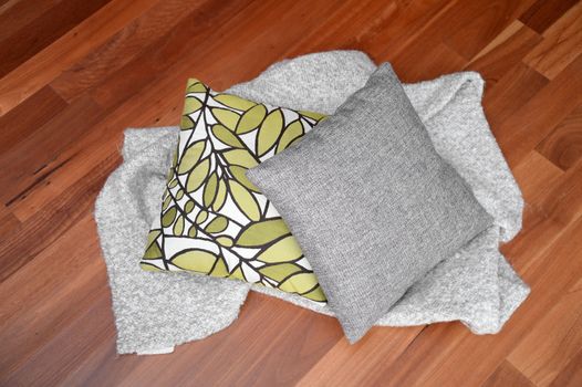 Scatter cushions isolated on a wooden floor