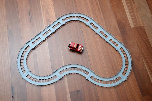 A toy race track on a wooden floor