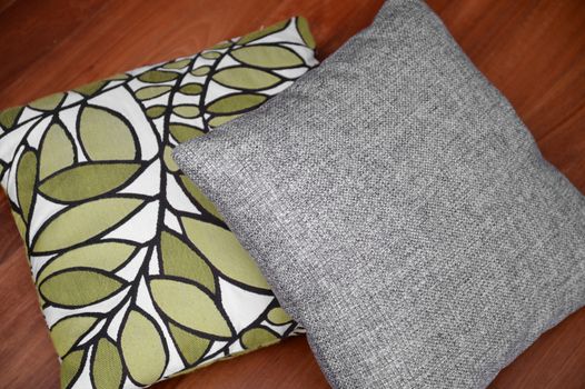 Scatter cushions isolated on a wooden floor