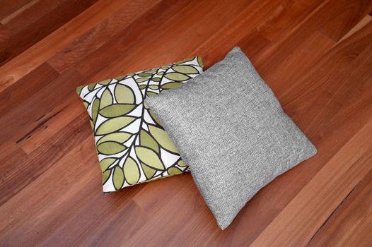 Scatter cushions isolated on a wooden floor