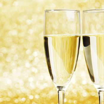 Two champagne glasses on golden background
