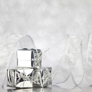 Boxes with christmas gifts on shiny silver background