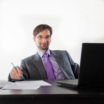 businessman at his desk with a laptop and papers