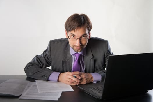 businessman at his desk with a laptop and papers