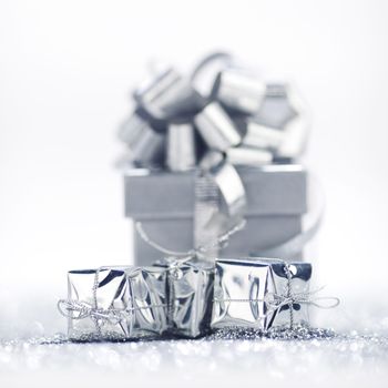 Gift boxes on glitter silver background with white copy space