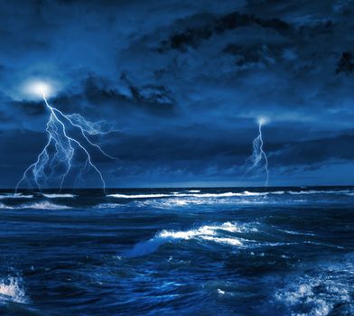 Image of dark night with lightning above stormy sea