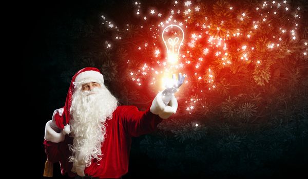 Image of Santa Claus with bulb. Idea concept