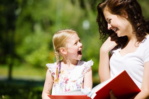 Image of cute girl and her mother playing in park