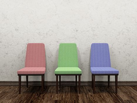 Three color chairs near a concrete wall