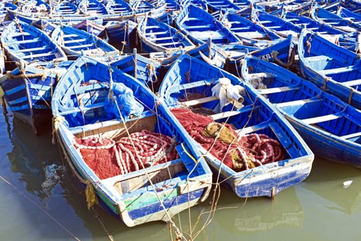 Blue fishing boats on an ocean coast in Essaouira, Morocco