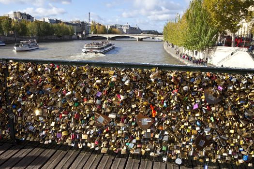 The Love Padlocks on Pont des Arts in Paris.  The view from the bridge takes in the Eiffel Tower, river Seine and Pont du Carrousel.