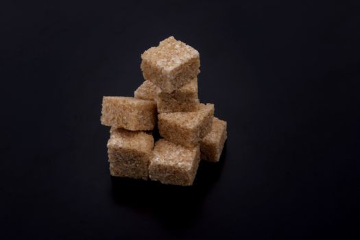 Photo of sugar cubes isolated on a black background