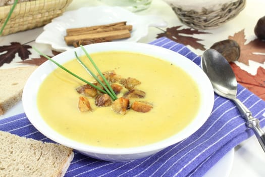 a bowl of sweet chestnut soup with roasted chestnuts and chives