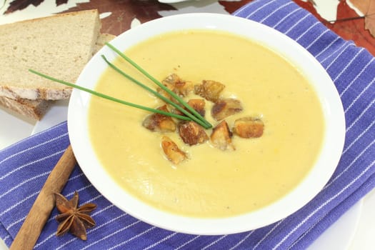 a bowl of sweet chestnut soup with roasted chestnuts and chives