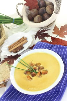 a bowl of sweet chestnut soup with roasted chestnuts and chives