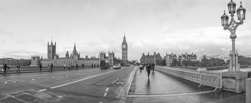 LONDON, ENGLAND, UK - OCTOBER 23: Tourists crossing Westminster Bridge in front of the Houses of Parliament and the Big Ben on October 23, 2013 in London, England, UK in black and white