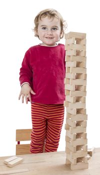 child with tower made of 	toy blocks. studio shot isolated on white background
