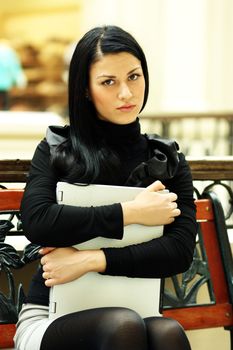 Beautiful young woman sitting on the bench