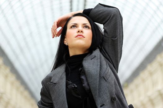 Young beautiful brunette in a gray coat