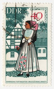 GDR - CIRCA 1960s: stamp printed in GDR (East Germany), shows young woman in traditional costume, circa 1960s