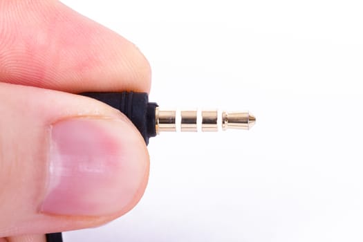 Hand holding stereo cable, isolated on white background.