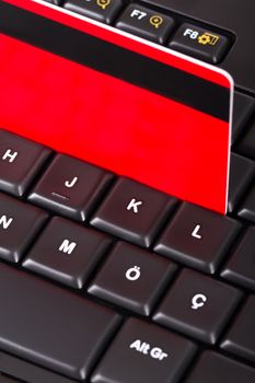 Close up view of credit card on black computer keyboard.