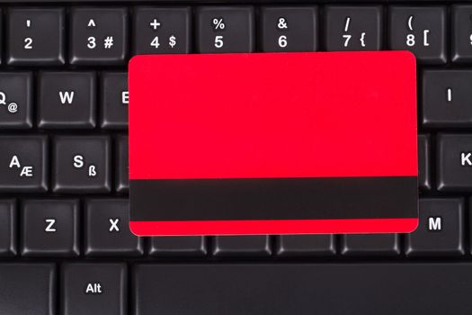 Close up view of credit card on black computer keyboard, top view.