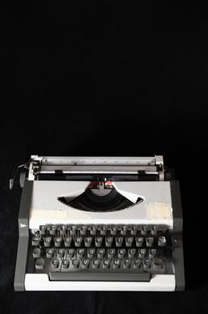 An Old Travel Vintage Typewriter on a Black Background