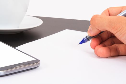 Hand writing blank, white paper, smart phone with empty  screen, ceramic coffee cup on wooden table, isolated on white background.