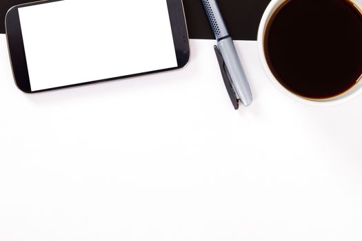 Smart phone with white, blank screen, empty paper, pen and black coffee in white cup on wooden table.