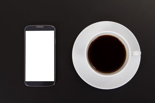 Smart phone with blank screen and black coffee in cup on wooden table.