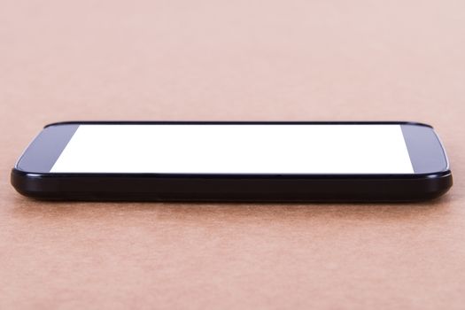 Smart phone with blank, white screen on wooden background.