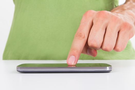 Finger touching smart phone with blank screen, front view, isolated on white background.