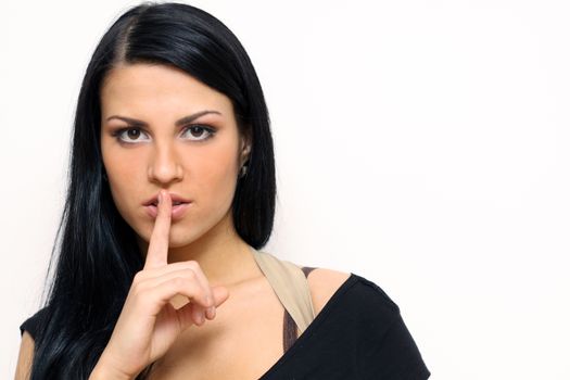 beautiful brunette with a finger on her lips showing to keep silence