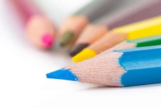 Close up view of colorful pencils, focused on blue pencil, isolated on white background.